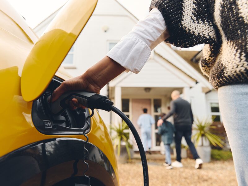 Woman,Plugging,Electric,Charger,Into,Car